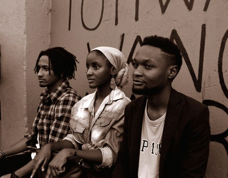 Friends Sitting Against Graffiti-Wall in Urban Setting